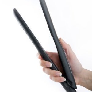 Someone holding a hair flat iron.