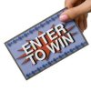 Photo of a hand holding a card that says Enter to Win.