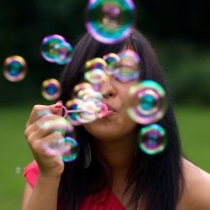 Young woman blowing bubbles.