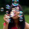 Young woman blowing bubbles.