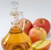 Apple cider vinegar in a glass decanter with apples.