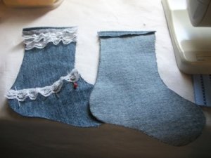 Two halves of a stocking. One has lace applied. The other shows how the top hem is turned down before sewing the two parts together.