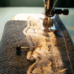 Closeup of sewing lace at the machine.