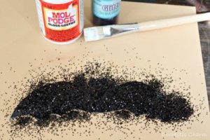 Applying glitter to bat cut out.