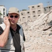 Man talk on the Phone in Front of Collapsed Building 