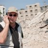 Man talk on the Phone in Front of Collapsed Building 