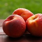 Wet nectarines sitting on a table.
