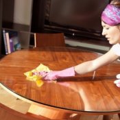 Woman dusting a table.