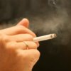 Hand holding a smoking cigarette.