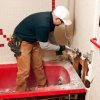 Saving Money on a Bathroom Remodel, Man Working on Remodeling a Bathroom