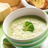 A bowl of soup garnished with broccoli and grated cheese.
