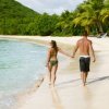 Saving Money on Your Honeymoon, A couple holding hands on a tropical beach.