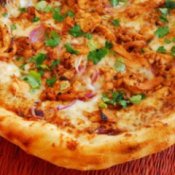 Corner of a BBQ chicken pizza.