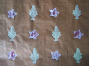 Star stenciled onto brown paper next to trees