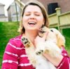 Woman holding a dog in arms.