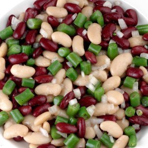 A salad made with kidney, wax and green beans, with onion and dressing.