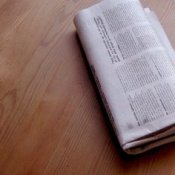 A newspaper on a wood table.