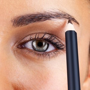 A woman using an eyebrow pencil.