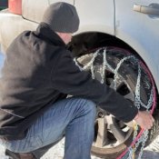 Putting on Snow Chains in Bad Weather, Man putting on snow chains.