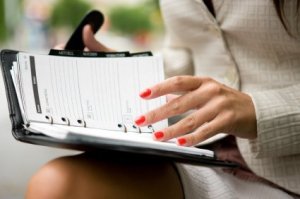 Woman Reviewing Her Busy Schedule in Day Planner