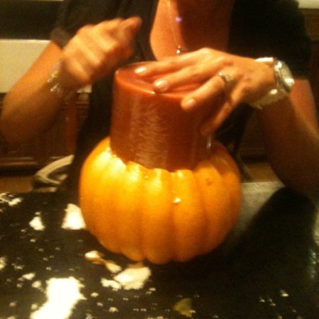 Putting candle into hollowed out pumpkin.