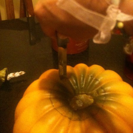 Cutting pumpkin along the marked circle.