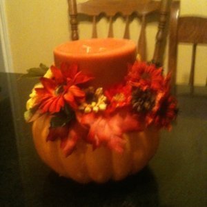 Stryofoam pumpkin with candle and artificial flowers. 