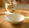 A person making salad dressing at home.