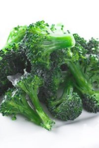 Frozen broccoli pieces on a plate.