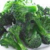 Frozen broccoli pieces on a plate.
