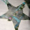 A Christmas star ornament made from felt and embellishments.