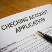 Checking account application with a pen.