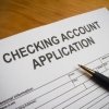 Checking account application with a pen.