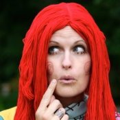Woman wearing a red yarn rag doll wig.