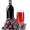 Glass of red wine in front of a bunch of grapes and a wine bottle.