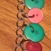 Buttons attached to flat link chain with jump rings.