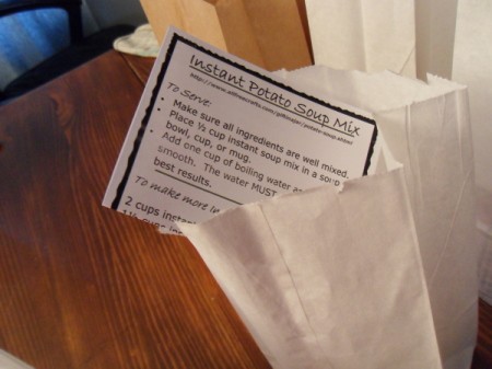Adding recipe card to white lunch bag.