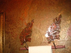 Copper colored leaf towel holder mounts.