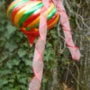 Large brightly colored ornament with decorative ribbon.