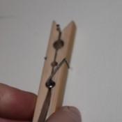 Protecting Fingers when Hammering Nails, Closeup picture of hand holding spring type clothespin against a white background