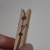 Protecting Fingers when Hammering Nails, Closeup picture of hand holding spring type clothespin against a white background
