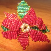 Beaded poinsettia flower with leaves.