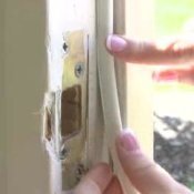 General Weatherization, Woman PUtting Weather Stripping on Window