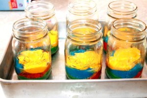 Mason jars filled with colored cake mix ready for baking.