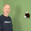 Fixing Large Holes in Walls, Man Standing next to Large Hole in Wall