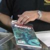 Comic Book Collecting, Man Putting Batman Comic into Plastic Sleeve
