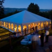 A nighttime photo of an outdoor tent wedding.