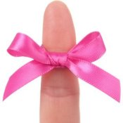 A finger with a pink bow tied on it.