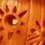 A flower or sun pattern carved into a pumpkin.