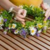 A person making a wildflower wreath.